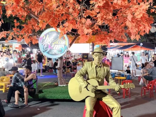 Street artists performing live music and circus acts at Son Tra Night Market in Da Nang.