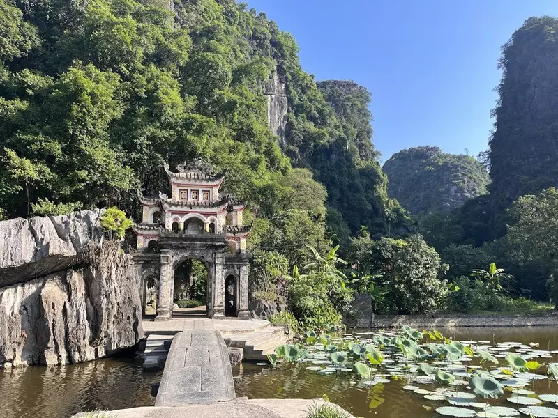 Tam Coc Bich Dong Travel Guide 2025: Top Things to Do, How to Get There & Insider Tips Scenic view of Bich Dong Pagoda with lotus flowers on the river in Ninh Binh