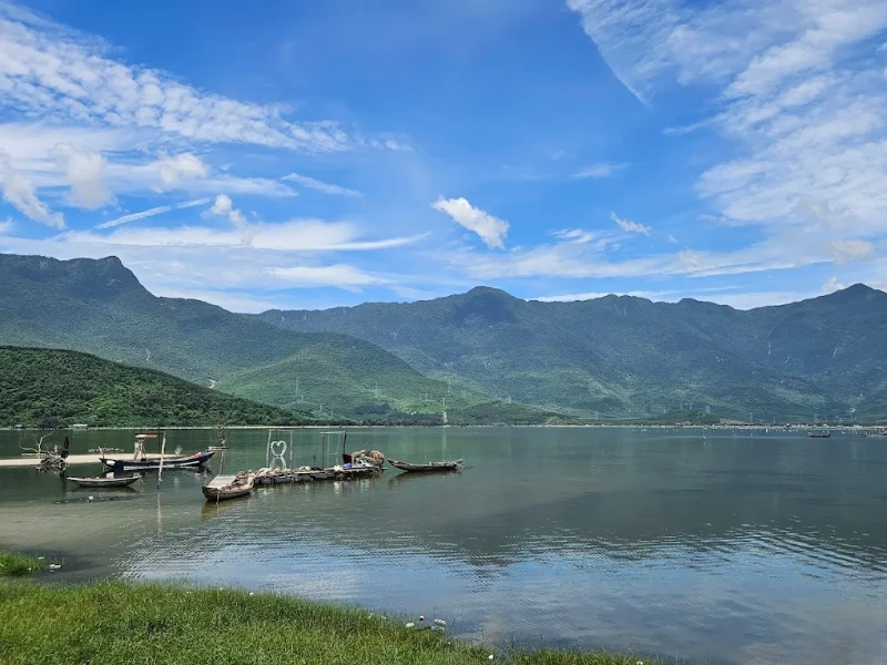 How to Explore Lap An Lagoon in Hue: Full Travel Tips & Guide People kayaking and stand-up paddleboarding on Lap An Lagoon in Hue, surrounded by mountains and clear skies.