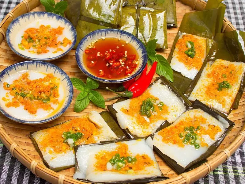 Explore An Dinh Palace in Hue – A Stunning Legacy of Royal Architecture A plate of traditional Hue Banh Beo with dipping sauce served near An Dinh Palace