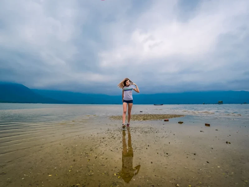 How to Explore Lap An Lagoon in Hue: Full Travel Tips & Guide Tourist walking along the sandy trail in Lap An Lagoon with Bach Ma Mountains in the background
